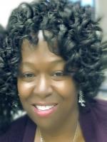 Close up of Denise Williams' face, a brown skin woman with black ringlet curls