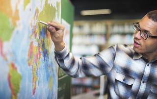 A male points on a map