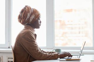 A woman types on a laptop