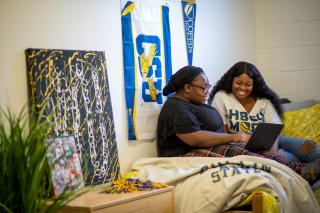 Students using a laptop in the dorm room